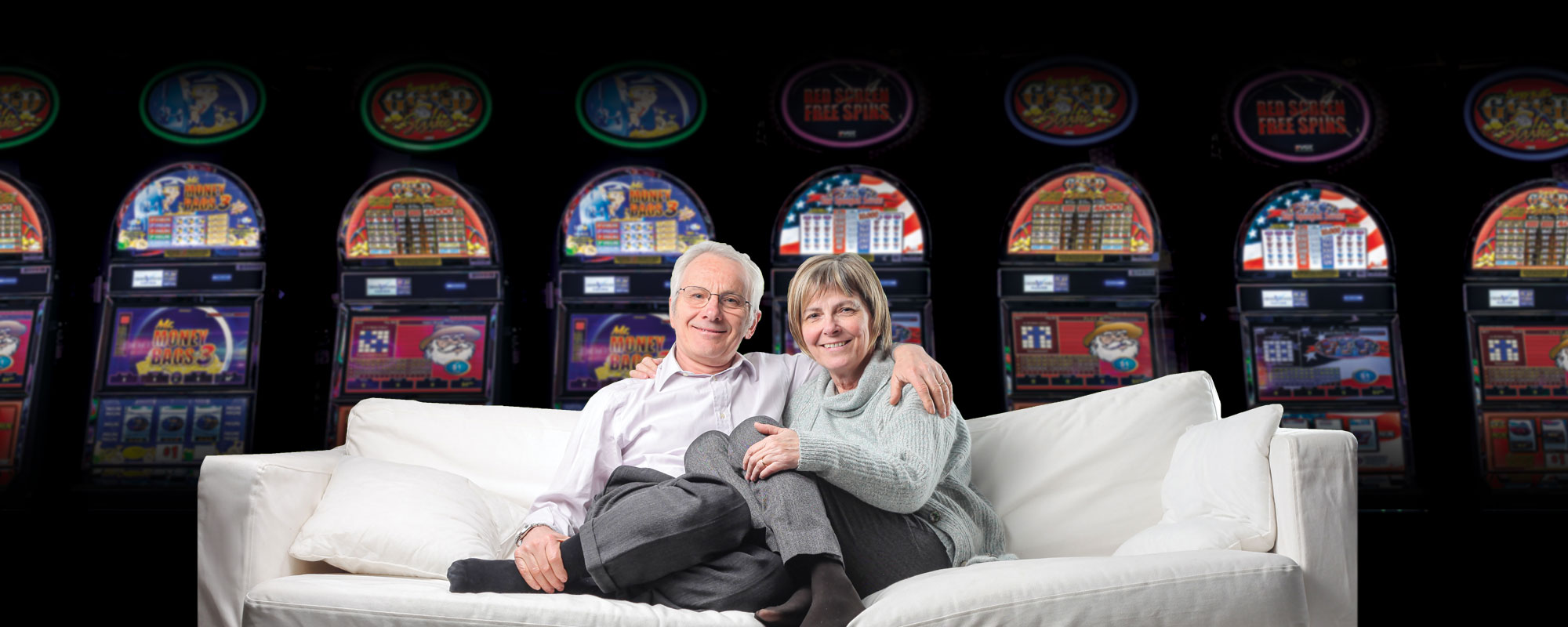 Couple on sofa in front of slot machines