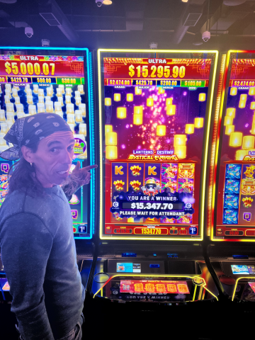 Anthony G. standing in front of machine with $15,347.70 jackpot win.