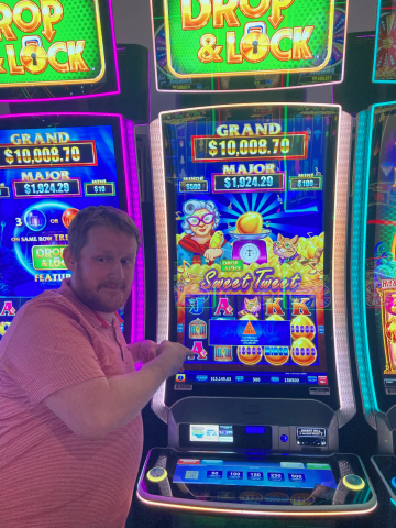 Daniel R. standing in front of machine with $15,050.00 jackpot win.