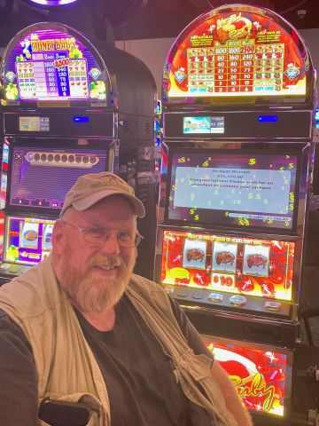 David T. standing in front of machine with $26,200.00 jackpot win.
