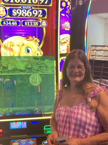 Deborah T. standing in front of machine with $28,126.51 jackpot win.