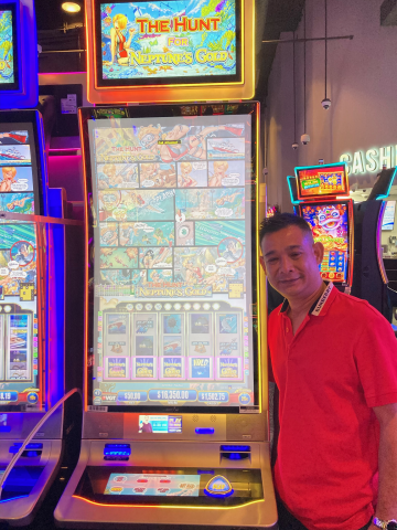Winner standing in front of machine with $16,350.00 jackpot win.