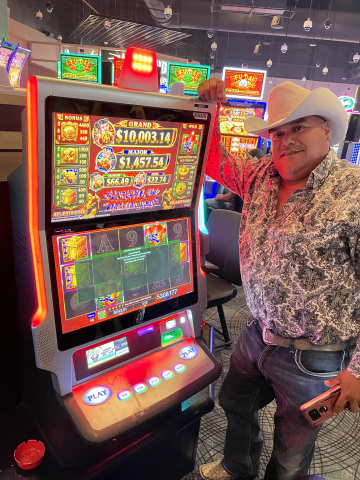 Gorge G. standing in front of machine with $53,081.77 jackpot win.
