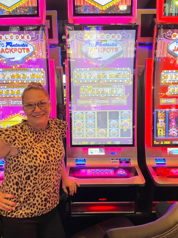 Michelle F. standing in front of machine with $11,400.00 jackpot win.