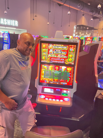 Terry F. standing in front of machine with $37,560.58 jackpot win.